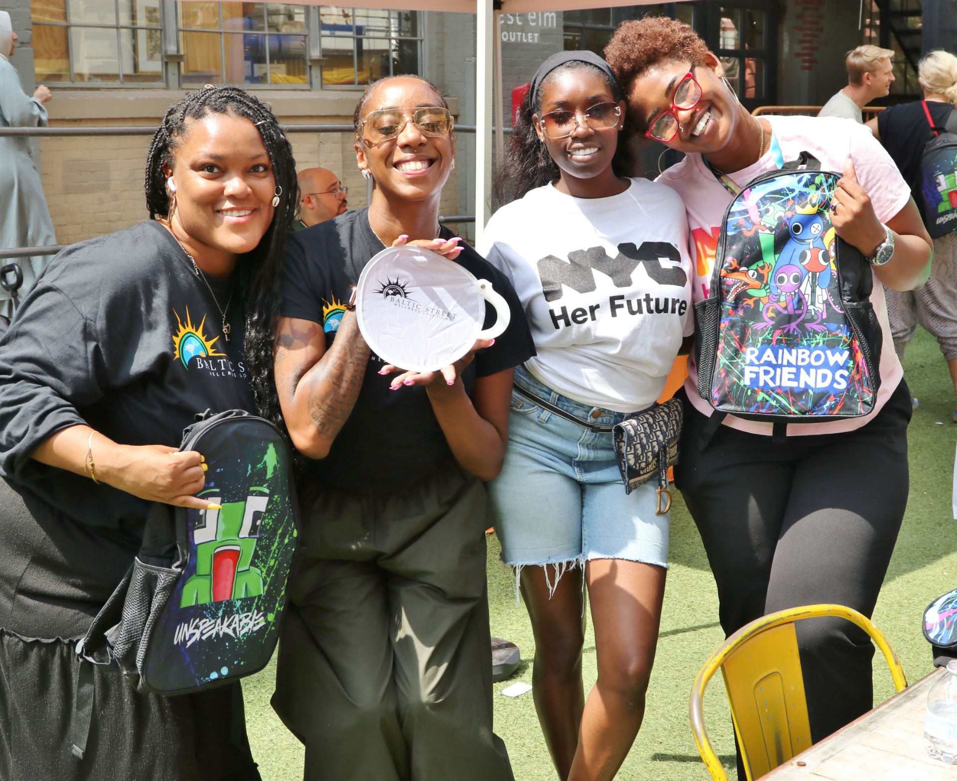 Baltic Street staff and partners holding donated backpacks