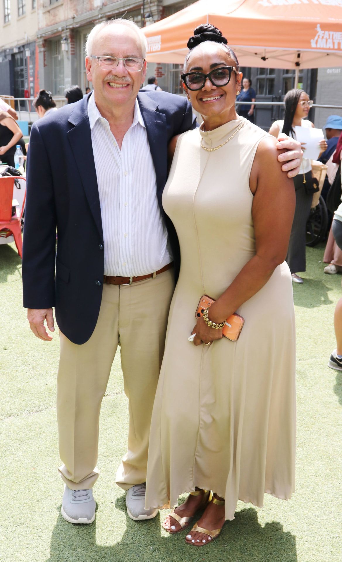 Two guests smiling arm in arm