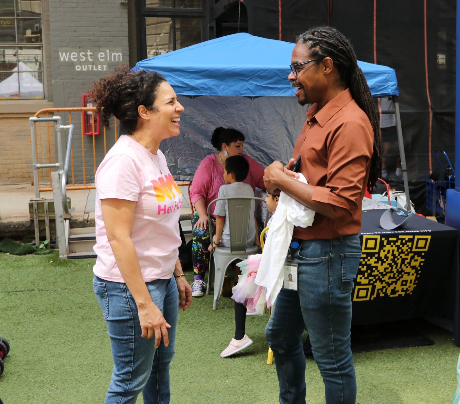 Two community members talking at an outreach table